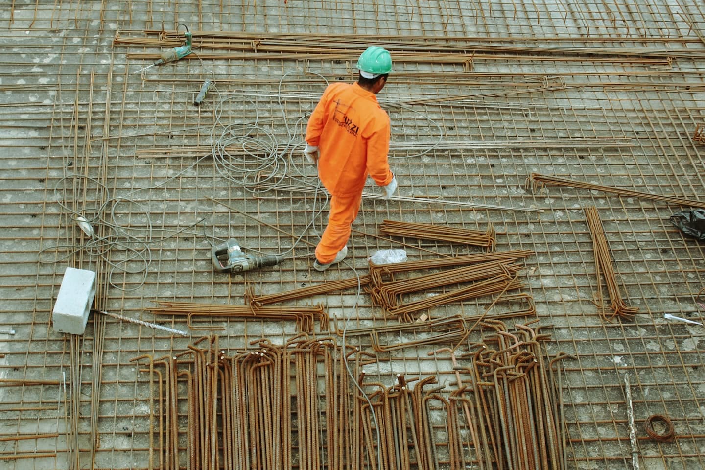 Profissional da construção civil trabalhando com armadura de ferro em obra